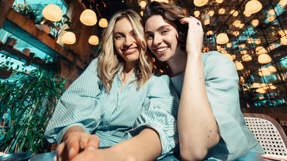 Zwei Frauen zahlen im Restaurant mit ihren gratis Cashback Cards Kreditkarten.