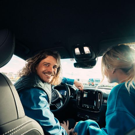 Cashback Cards - Junges Paar sitzt im Mietauto während einer Reise 